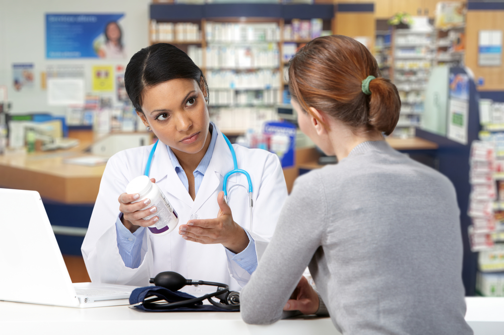 Asian medical doctor with patient woman over pharmacy background.