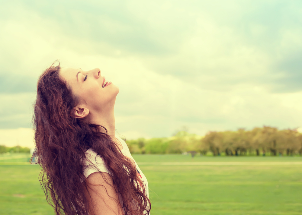 Side profile woman smiling looking up to blue sky celebrating enjoying freedom. Positive emotion face expression life perception success, peace of mind concept. Free happy girl