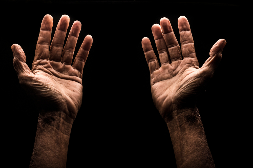 Praying hand in the dark
