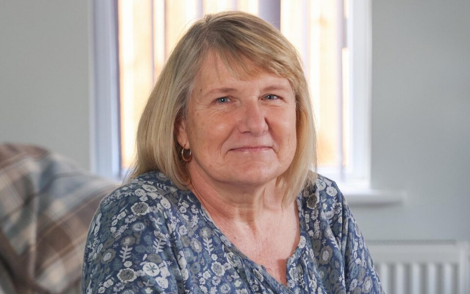 Close up of Julie Holder with a window in the background.