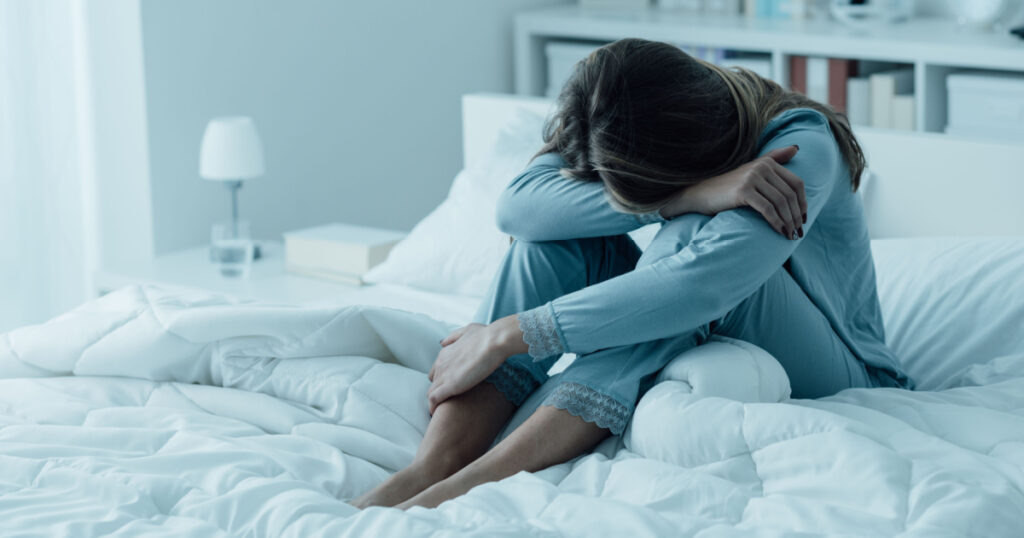 Depressed woman awake in the night, she is exhausted and suffering from insomnia