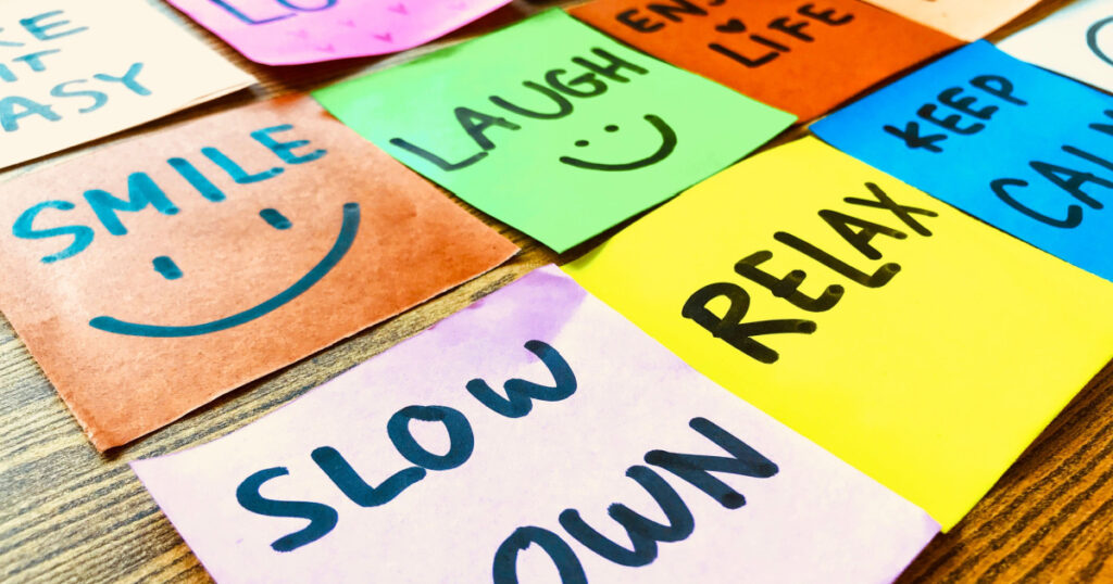 Colorful of notes with hand writing of positive attitude words on the wooden background