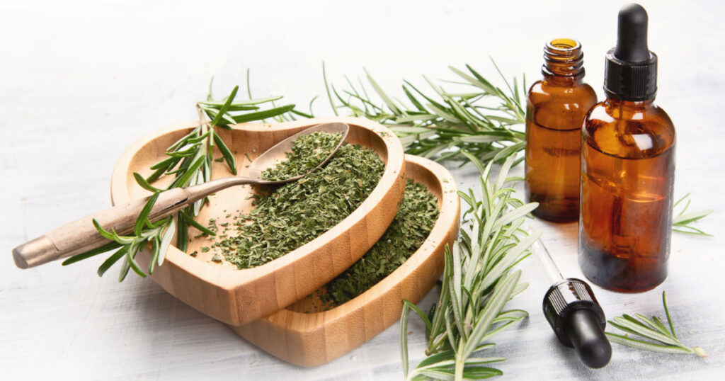 Natural rosemary essential oil with fresh rosemary twigs