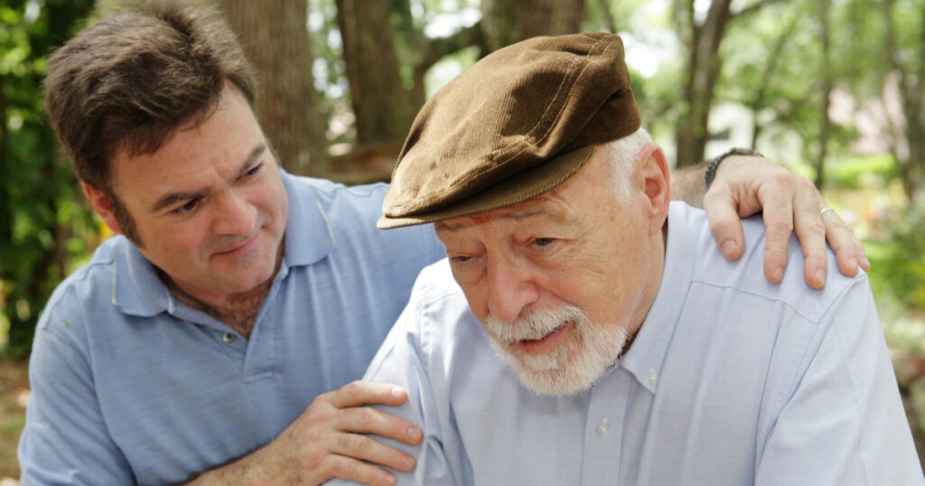 Senior man in failing health and his worried middle-aged son. Focus on Senior man.