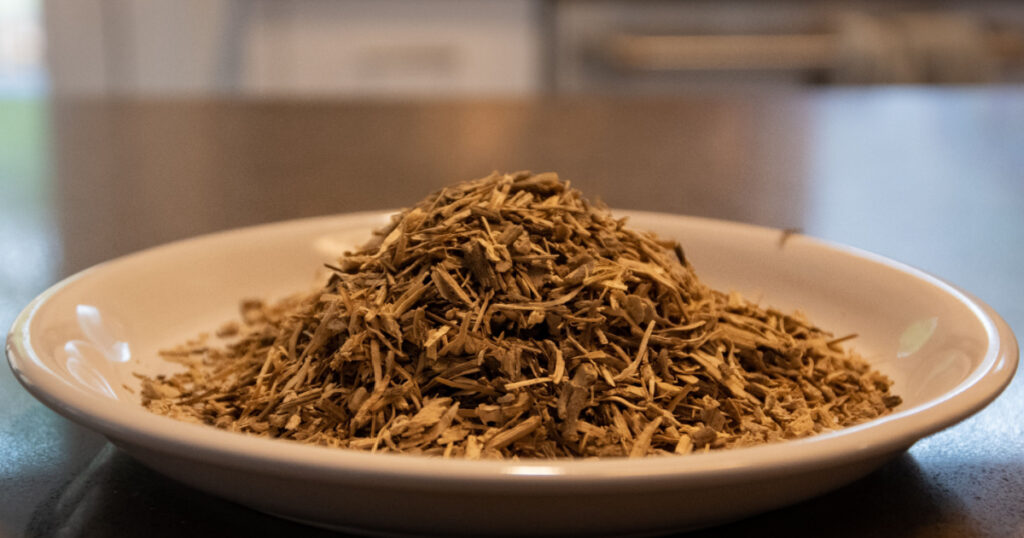 Kava Kava root on plate in a kitchen setting, A well known organic herbal tea used to relax the body. Wpoden spoon filled with the root.