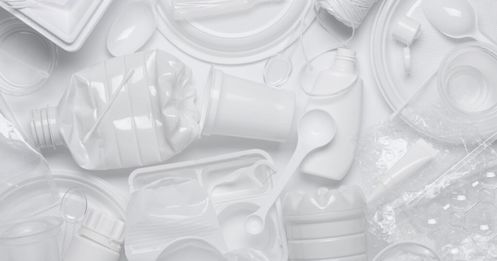 Plastic waste. Single-use plastic objects, ecological pollution. White packaging plastic products, top view flat lay.