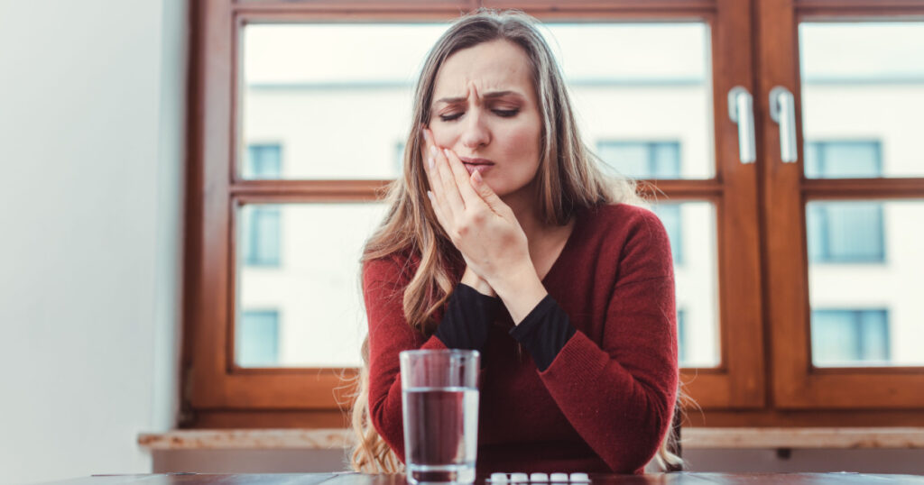 Woman with toothache holding her cheek in pain