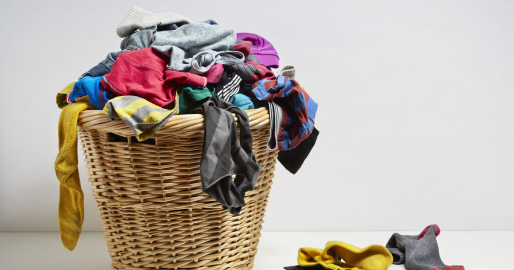 Overflowing laundry basket. Household chore concept on white background