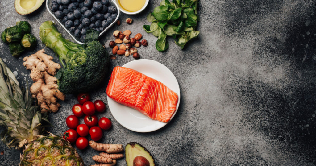 Anti inflammatory diet concept. Set of foods that help to reduce inflammation - plant based ingredients, fresh fruit, vegetables. Healthy diet products, top view, stone background copy space. Toned