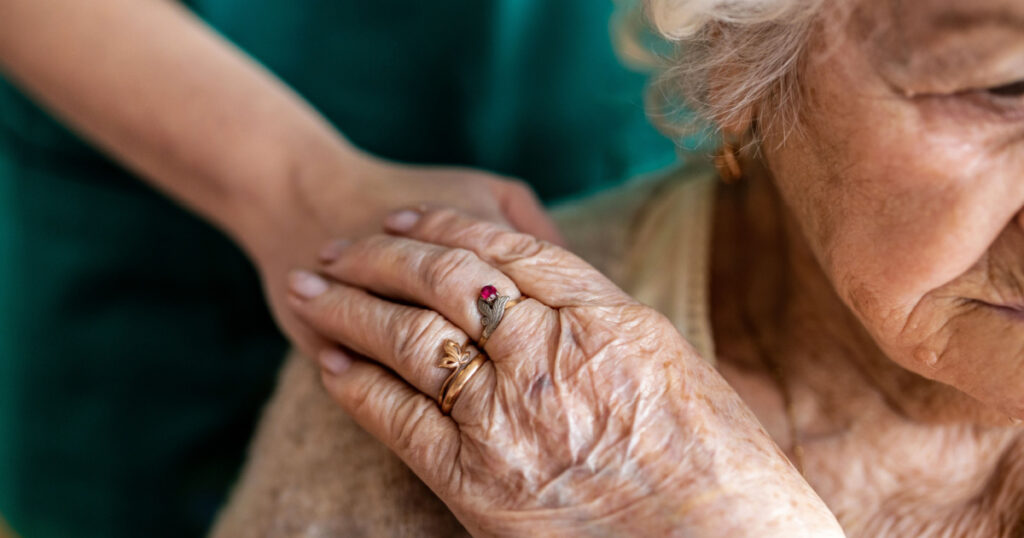 Cropped shot of a senior woman holding hands with a nurse