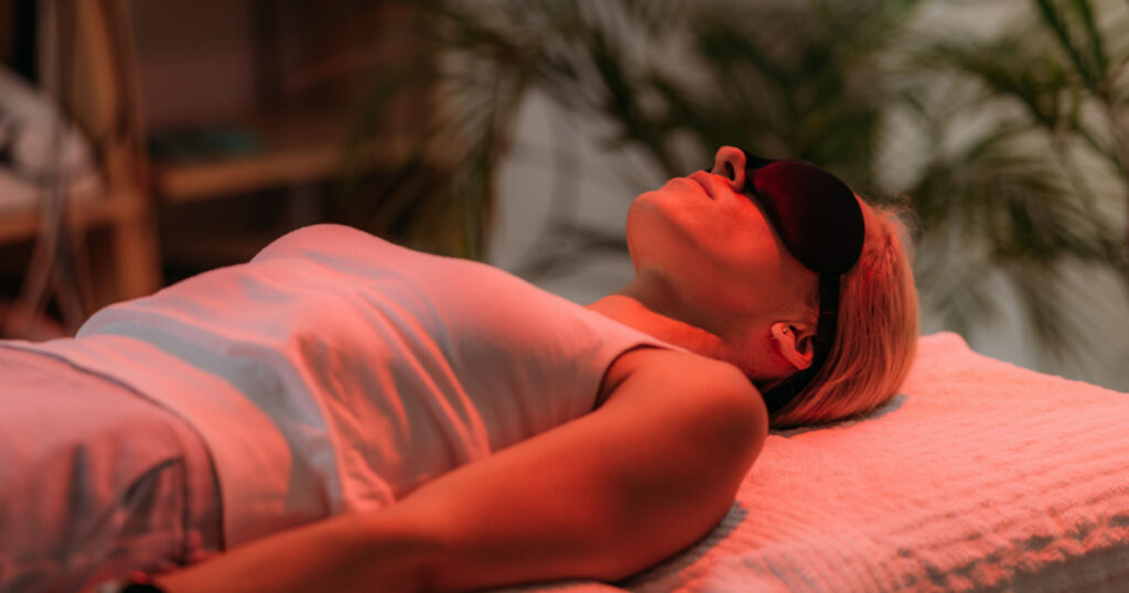 Color light therapy. Female face under the red light