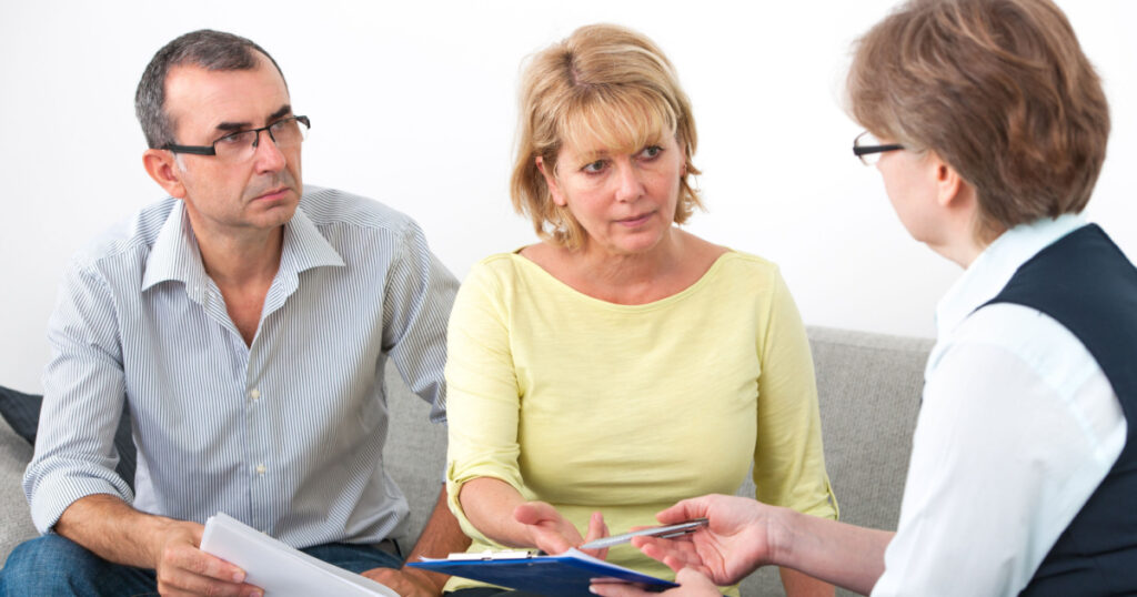 Mature couple getting financial advice from consultant at home