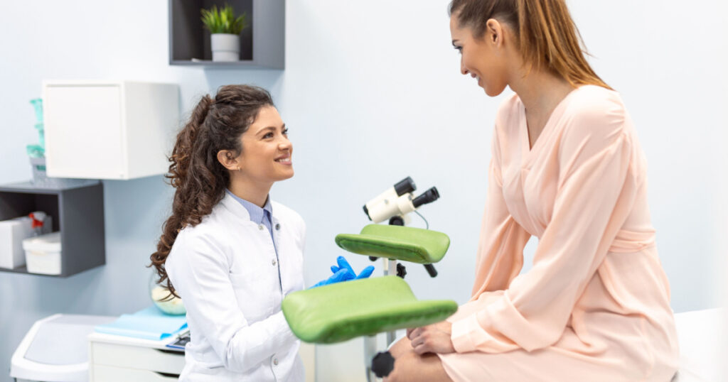 Gynecologist preparing for an examination procedure for a pregnant woman sitting on a gynecological chair in the office