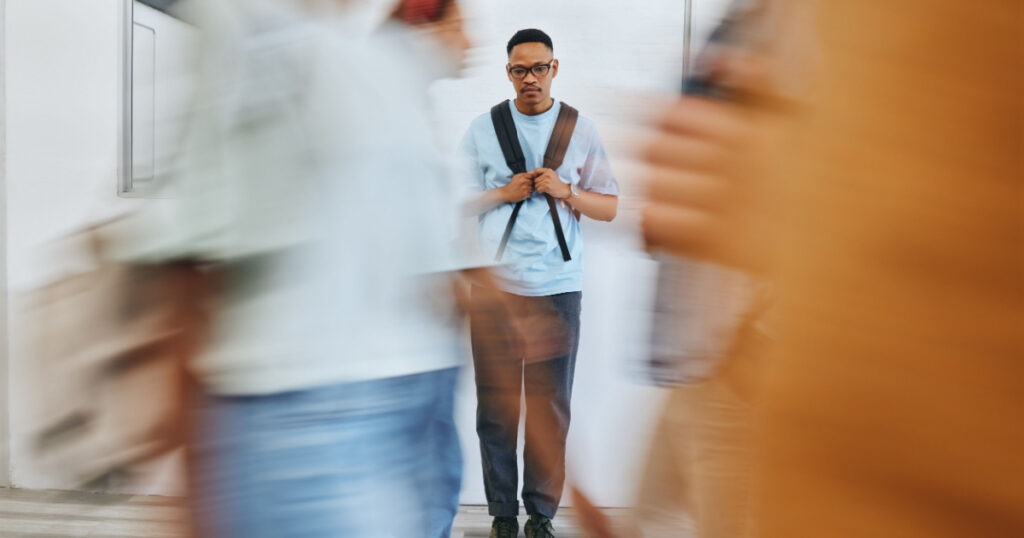 Bullying, depression and sad university student, black man and mental health problems in busy college. Social anxiety, depressed and lonely campus guy, loser and victim fail in school youth education