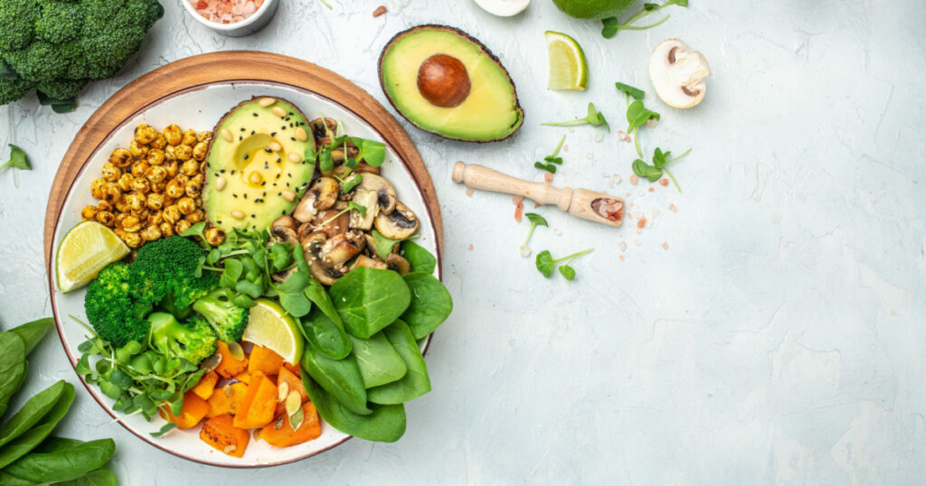 healthy vegan lunch bowl with Avocado, mushrooms, broccoli, spinach, chickpeas, pumpkin on a light background. vegetables salad. Top view.