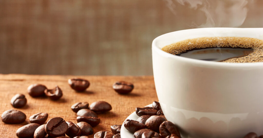 Coffee cup and coffee beans on table