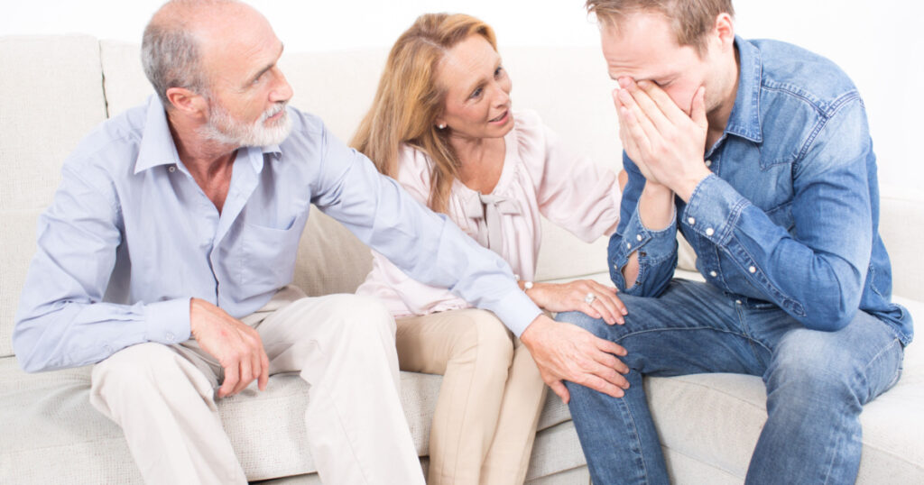 Parents comforting their son