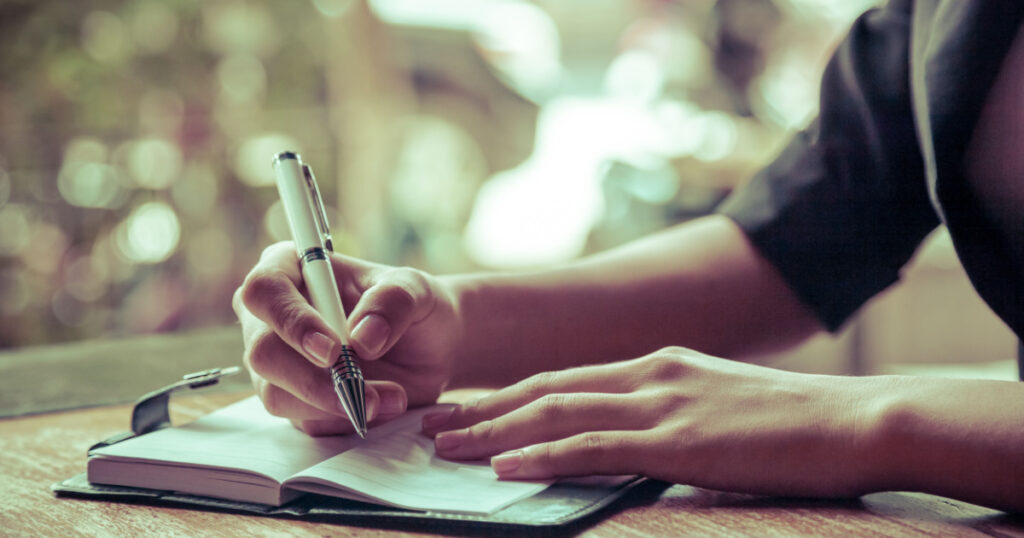 close up of woman writing her journal