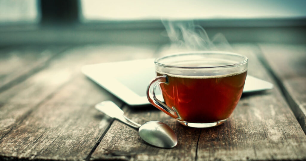 Hot tea cup on a frosty winter day window background
