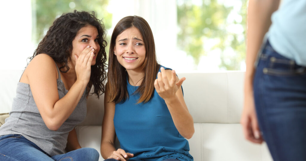 Two gossip friends criticizing another woman at home