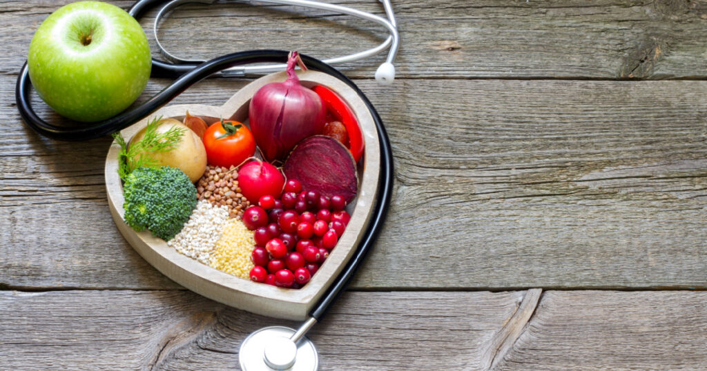 Healthy food in heart and cholesterol diet concept on vintage boards
