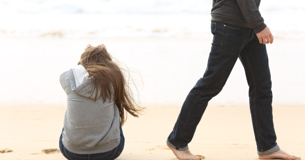 Teenager couple breaking up and ending relation after argument. Boyfriend legs leaves his sad girlfriend and go away