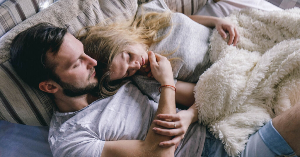 young beautiful couple embracing in bed