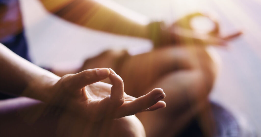 Closeup of woman's hands meditating indoors