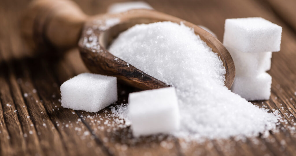 Portion of White Sugar (detailed close-up shot; selective focus) on wooden background