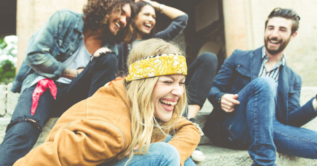 Group of four friends laughing out loud outdoor, sharing good and positive mood
