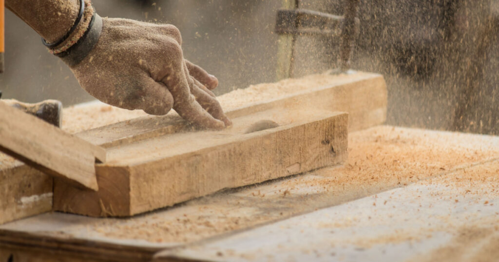 Handmade and craft furniture concept: Carpenter engaged in processing wood at the sawmill