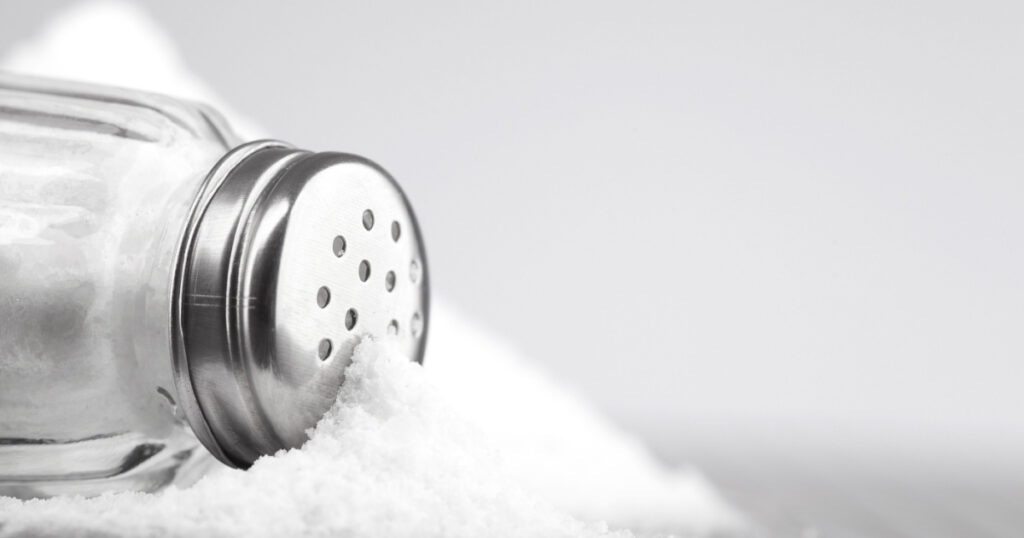 glass salt shaker on gray table and white background for text
