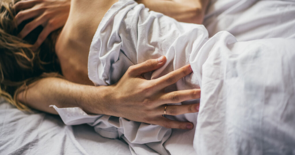 beautiful couple lying together on the bed. male hand closeup