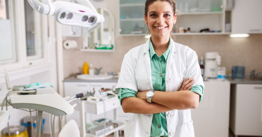 Portrait of female dentist .She standing in her dentist office.