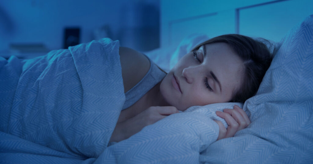 Woman peacefully sleeping in bed at night