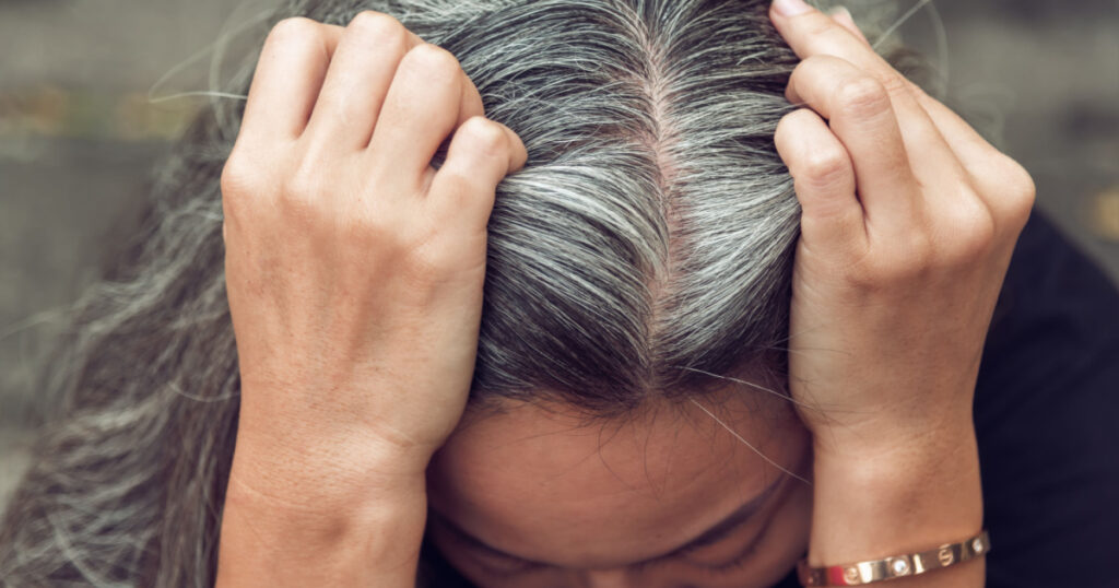 Closeup sad asian young beautiful woman and gray hair with worried stressed face expression looking down