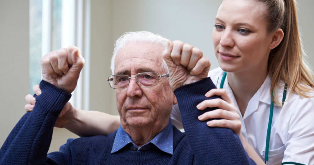 Nurse Assessing Stroke Victim By Raising Arms