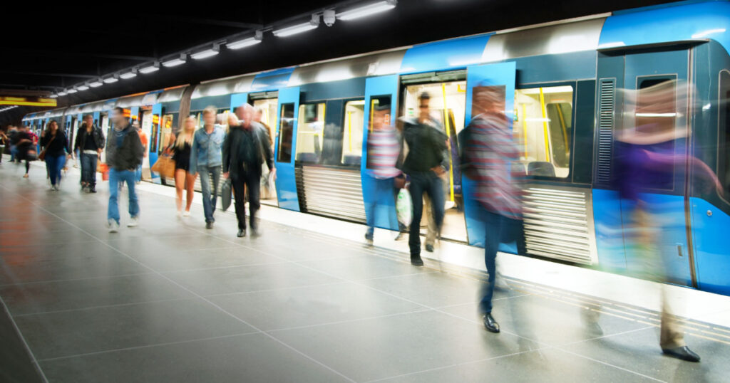 Blurred people on subway platform leaving the train