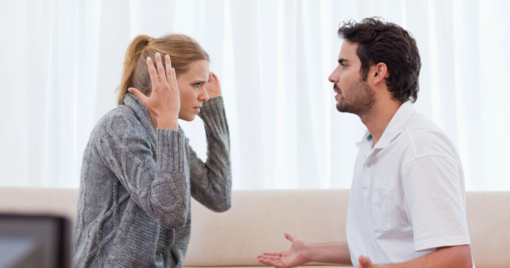 Young couple arguing in their living room