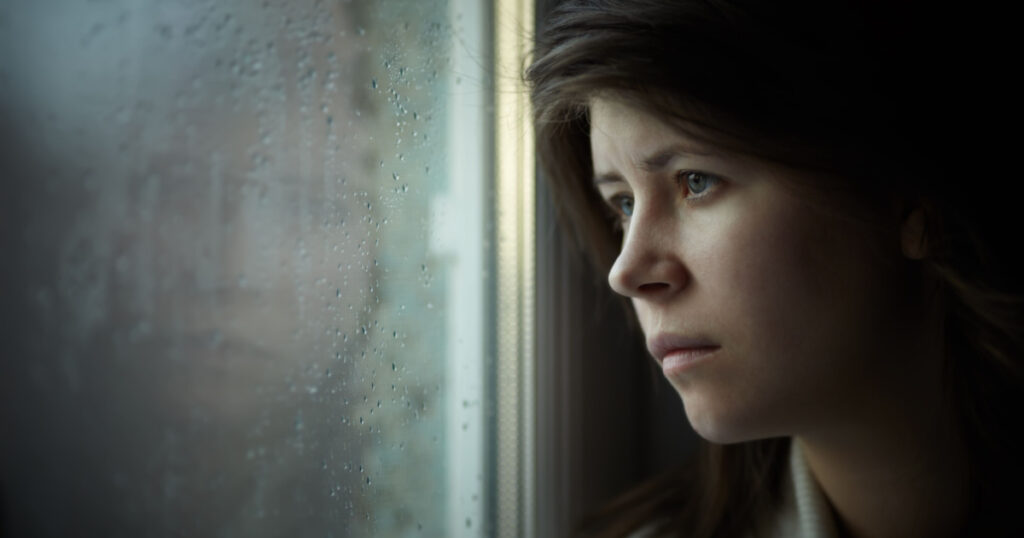 lonely girl near window thinking about something