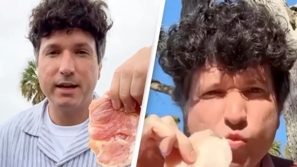 Man holding raw chicken with trees in the background