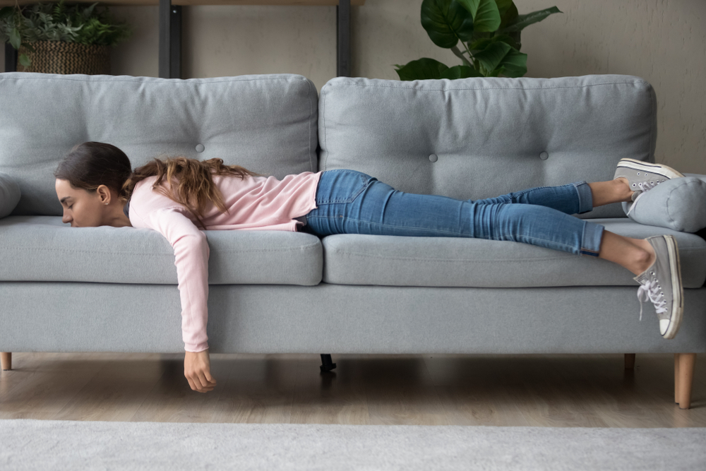 Full length of girl lying rest at home in living room buried her face in couch feels exhaustion having day nap lack of energy after party sleepless night or overworked, too tired no motivation concept
