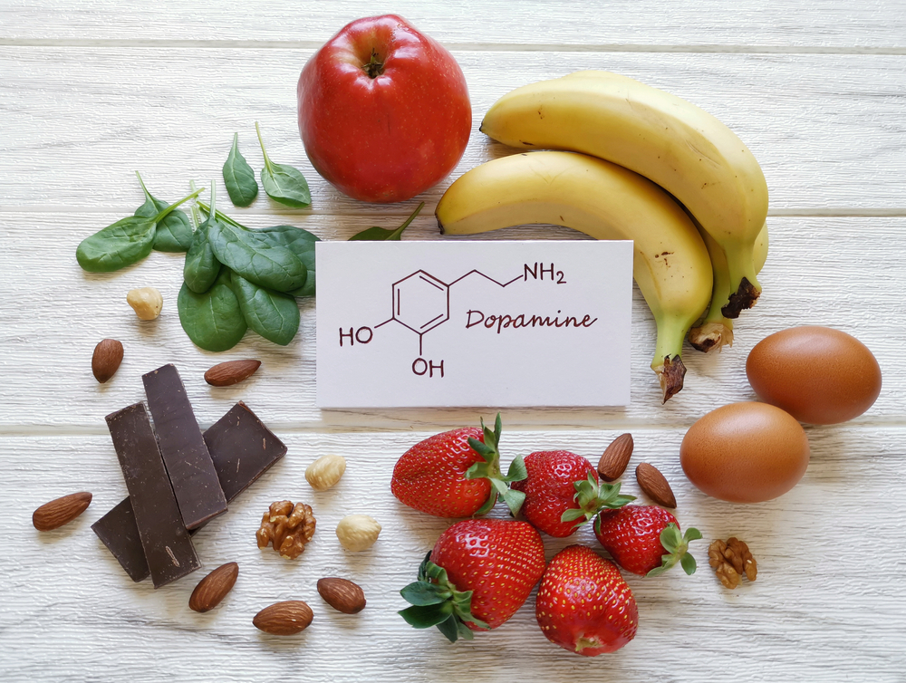 Dopamine-boosting foods. Assortment of food for good mood and happiness. Healthful foods that may help boost dopamine. Natural sources of dopamine with structural chemical formula of hormone dopamine.
