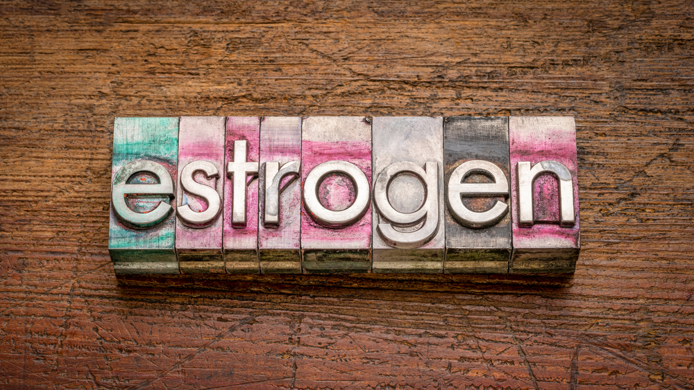 estrogen word abstract in gritty vintage letterpress metal type stained by printing ink against rustic wood, health and hormone concept

