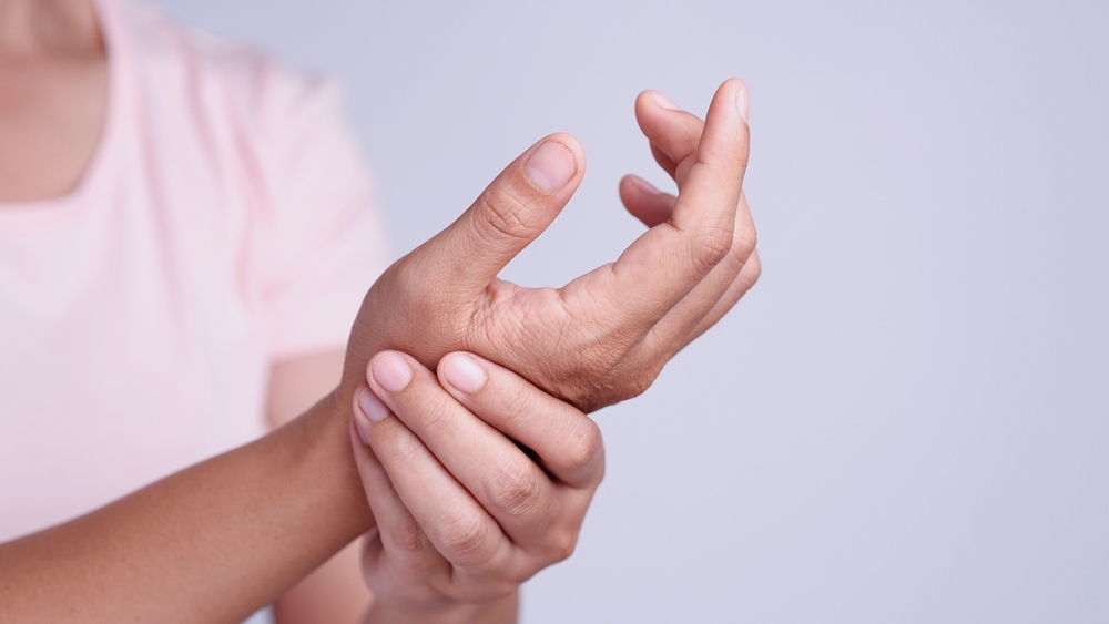 Close up young Asian women suffering pain in hand around finger joint and using the thumb to massage, exercise, treatment her painful. Concept of Office syndrome, Neuropathy, hand pain, Healthy Care.