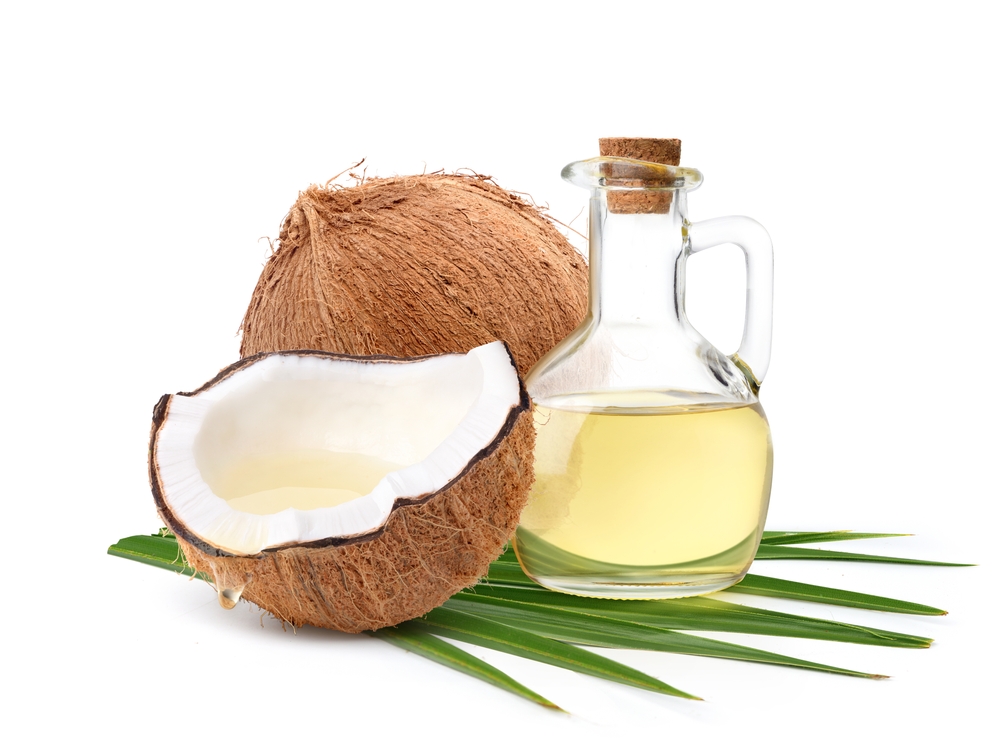 Coconut oil with coconut fruits cut in half isolated on white background.