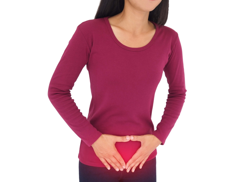 Woman suffering from pelvic pain with uterus and ovaries anatomy. Cause of pain inclued dysmenorrhea, edometriosis, cervical cancer. Health concept. Closeup photo, blurred.
