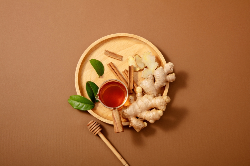 Turmeric ginger tea preparation with healthy ingredients on Brown background, top view.