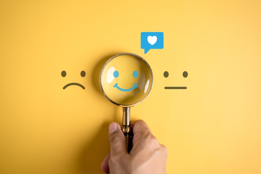 Smile happy face inside of magnifier glass with love icon massge between sad and normal emotion, Positive emotion, Mental health care concept.
