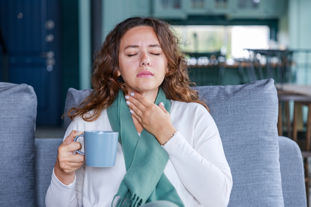 Young woman touching painful neck, sore throat for flu, cold and infection

